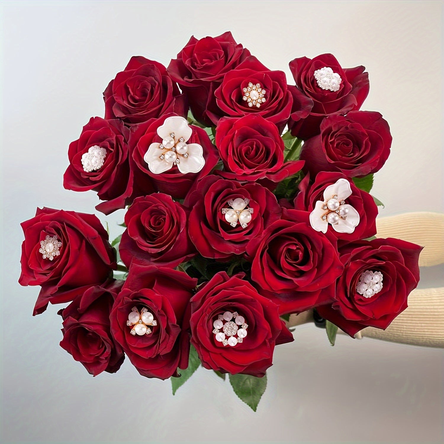 Bouquet of red roses with decorative elements on a light background