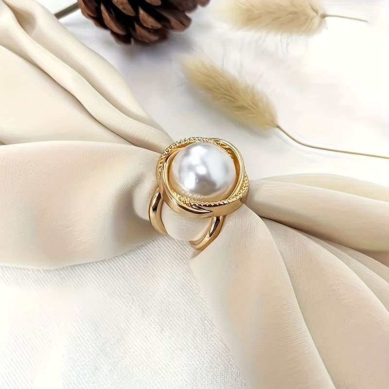 Gold ring with a pearl on a beige fabric background