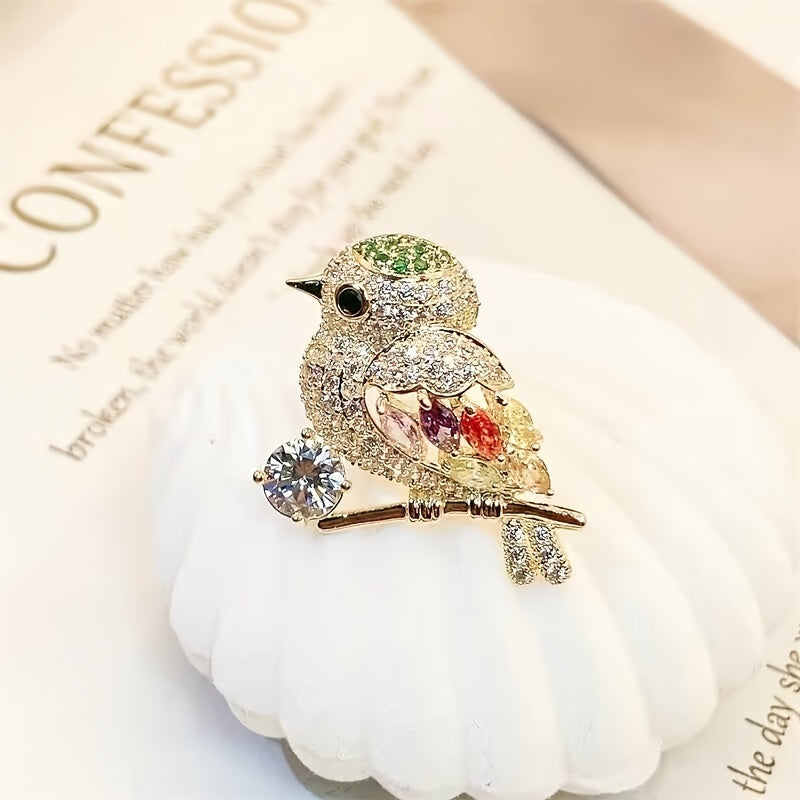 Decorative bird brooch with gemstones on a white surface