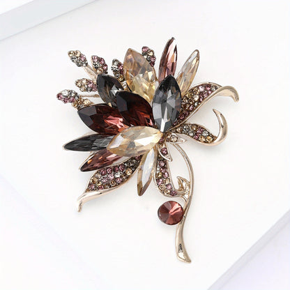 Decorative brooch with multicolored gemstones on a white background