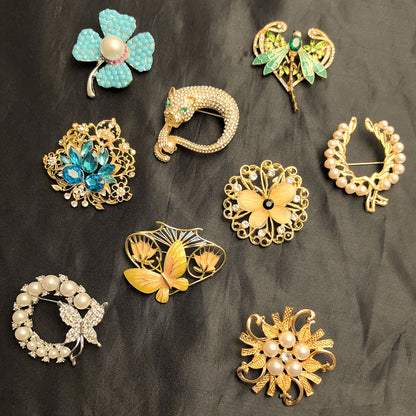 Collection of decorative brooches on a dark fabric background