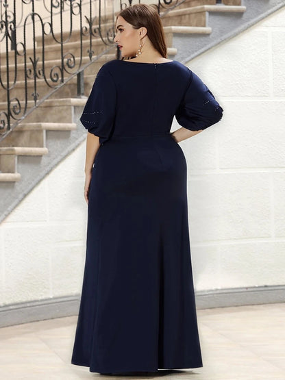 Woman wearing a navy blue dress standing on a staircase.