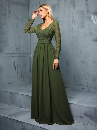 Woman wearing a green evening gown against a gray concrete wall.