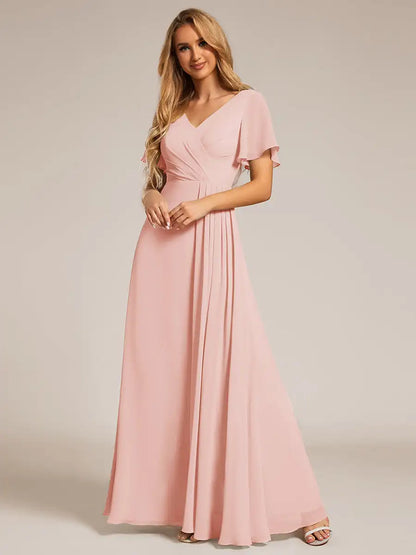 Woman wearing a pink dress against a plain background