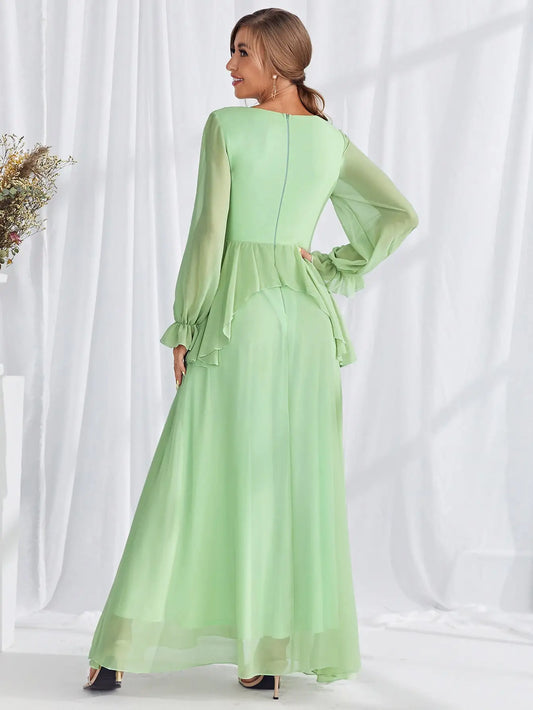 Woman wearing a light green dress with long sleeves against a white background