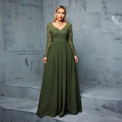 Woman wearing a green evening gown against a gray concrete wall.