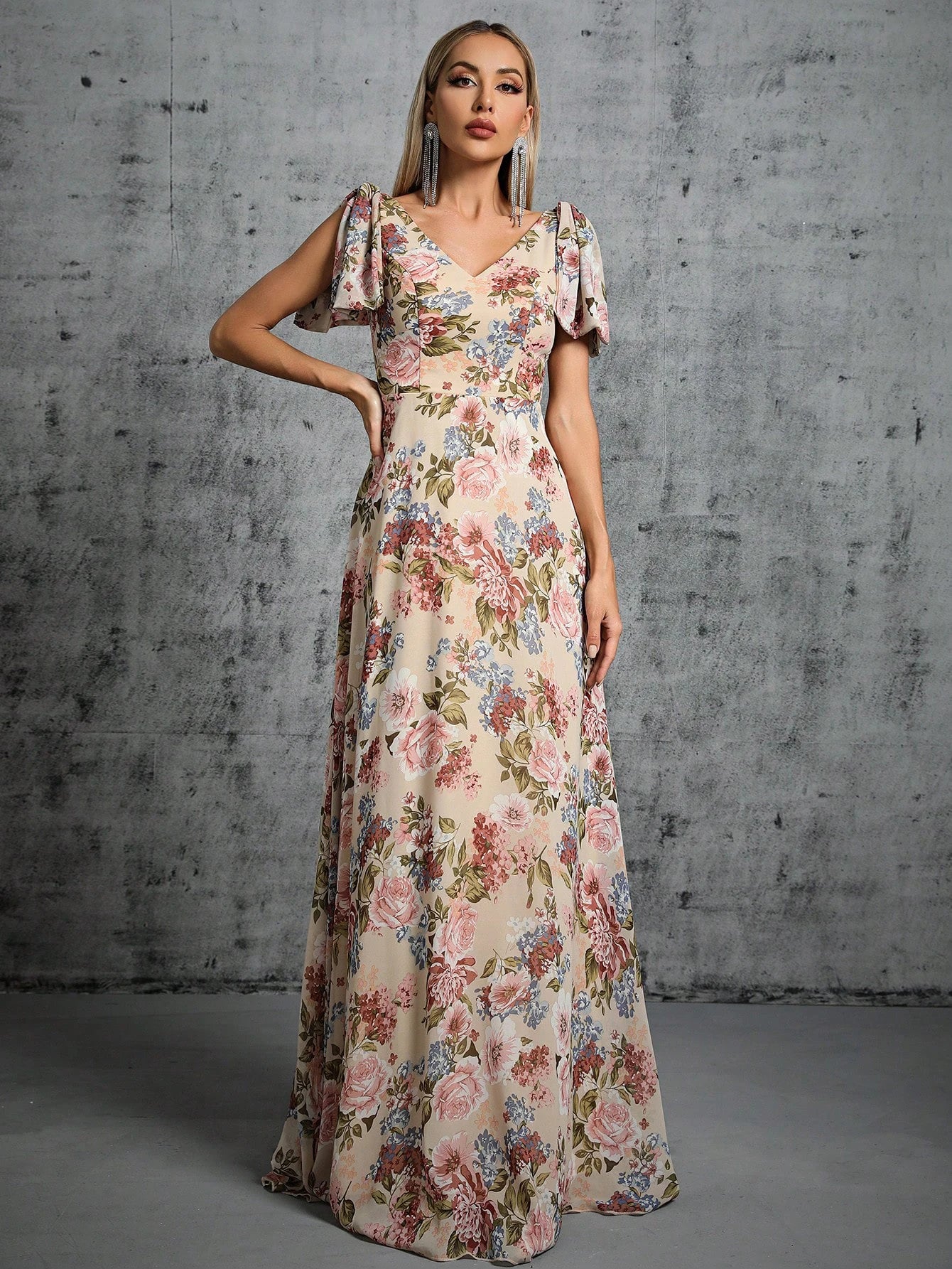 Woman wearing a floral dress against a textured gray wall