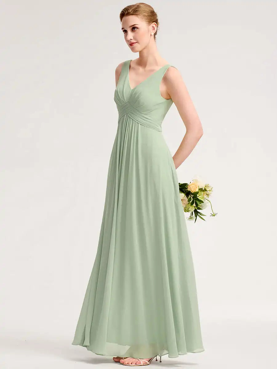 Woman wearing a long light green dress holding flowers on a white background