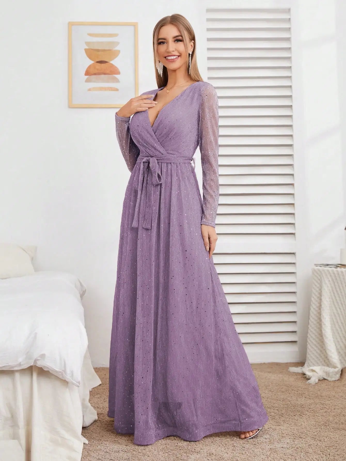 Woman wearing a long purple dress in a room with white walls and furniture.