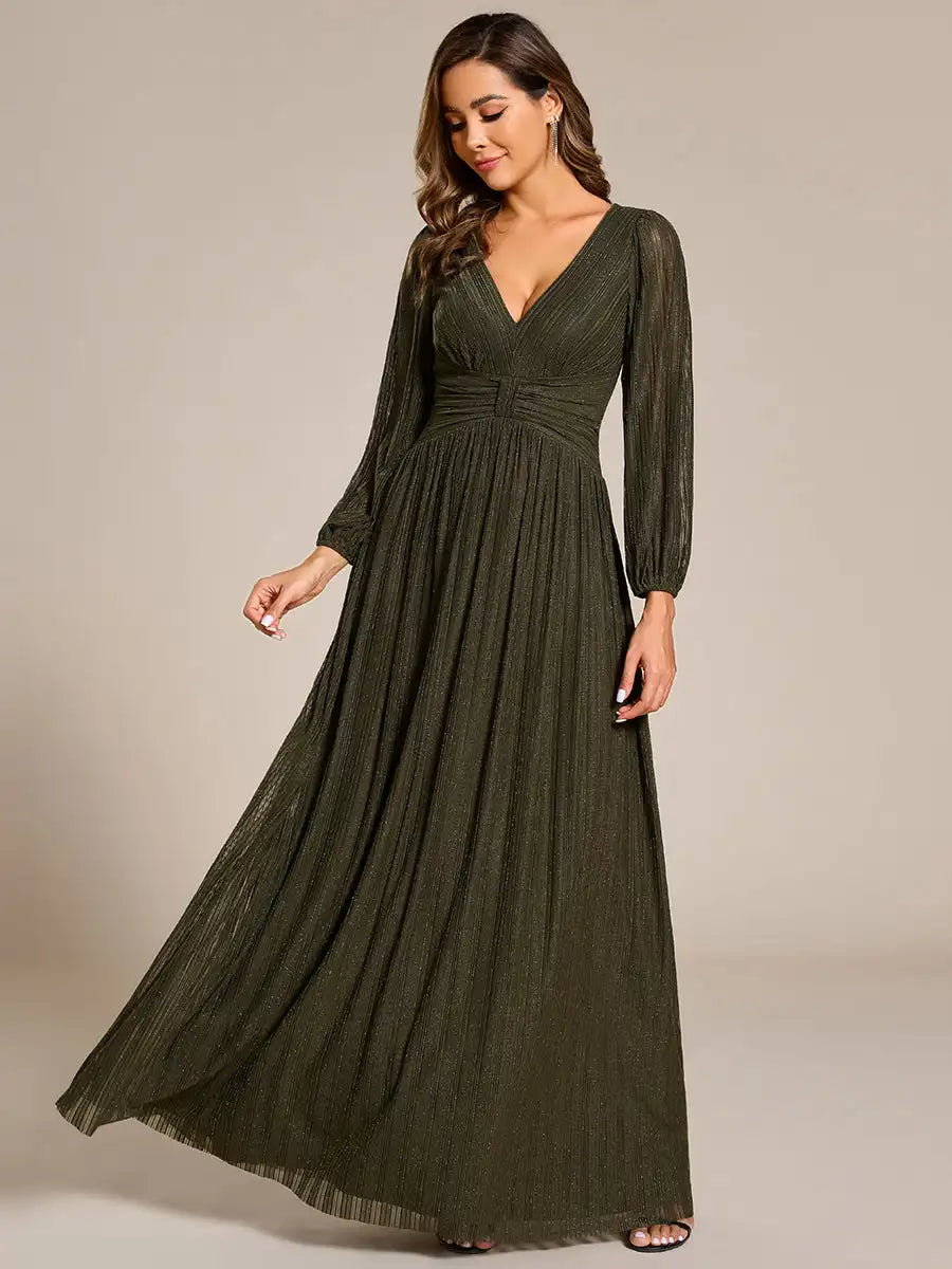 Woman wearing a long green dress against a neutral background