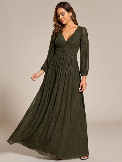 Woman wearing a long green dress against a neutral background
