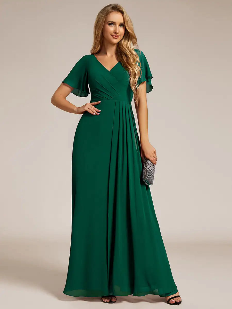 Woman wearing a green evening gown on a beige background