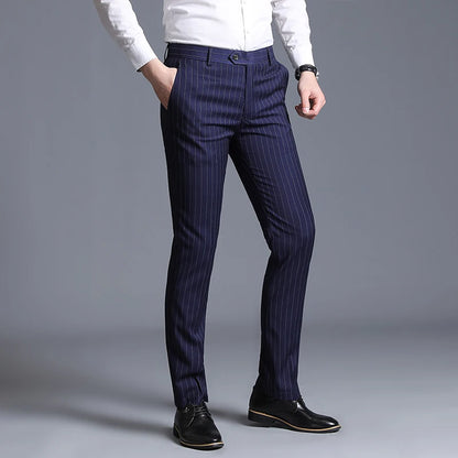 Navy pinstripe pants worn with a white shirt on a gray background