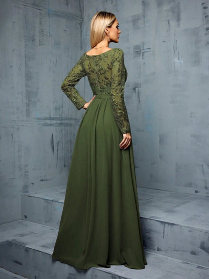 Woman wearing a green lace dress against a gray textured wall.