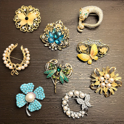 Collection of decorative brooches on a wooden surface