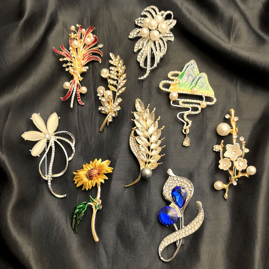 Collection of various brooches on a dark fabric background