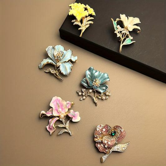 Set of colorful floral brooches on a brown surface with a black box.